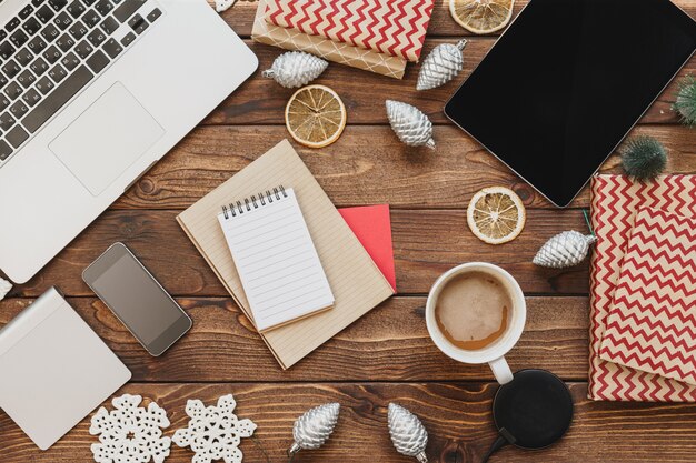 Top-down shot of a desk organized for online shopping, featuring a laptop displaying Green Monday deals, a notebook with a budget list, a credit card, and a cup of coffee.