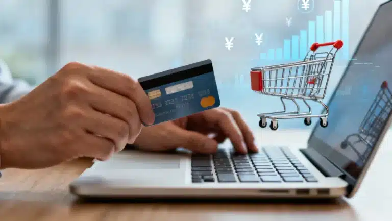 Hand holding credit card over laptop for online shopping, maximizing cash back