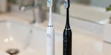 Two modern electric toothbrushes with five brushing modes displayed.